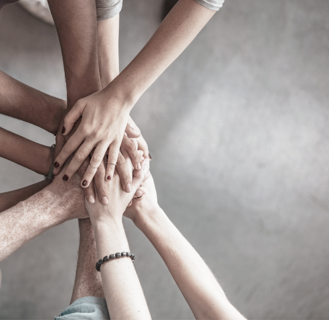 Hands of different people coming stacking on top of one and another symbolizing support services of One&Co